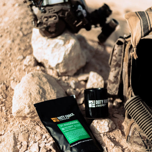 Café 3ª Imaginaria Duty Force Coffee junto a equipo táctico y taza en zona desértica.